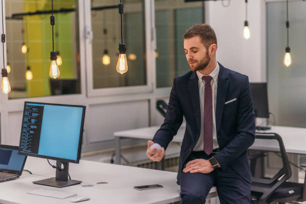 istock Formally dressed businessman (boss) leaning on a desk in modern an office 1369949946