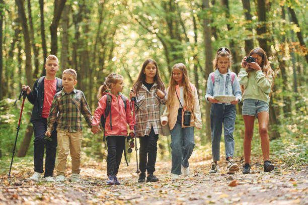 istock In green forest. Kids having a walk outdoors at summer daytime together 1369950899