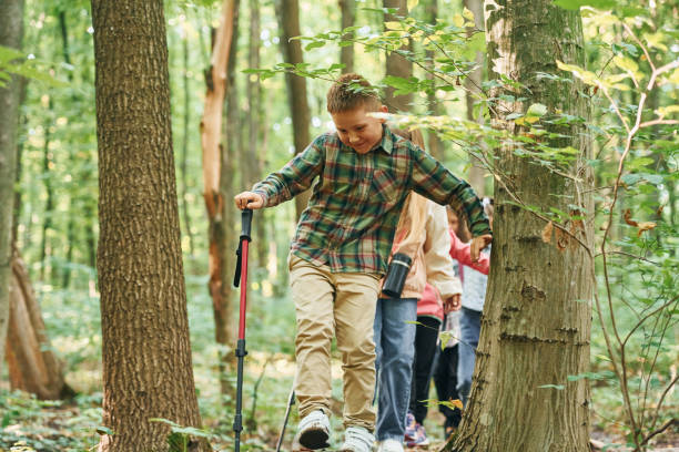 istock In green forest. Kids having a walk outdoors at summer daytime together 1369950918