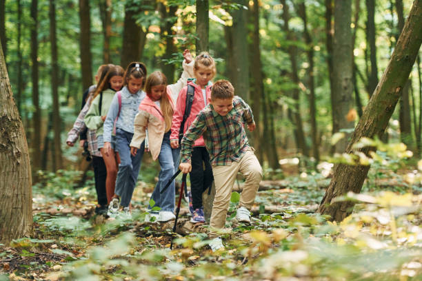 istock In green forest. Kids having a walk outdoors at summer daytime together 1369950934