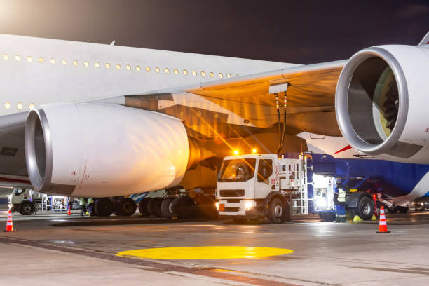 process of aircraft jet airplane refueling by high pressure fuel supply truck at night. - fixed wing aircraft imagens e fotografias de stock