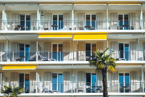 balconies with yellow sun blinds in Locarno in the morning sun