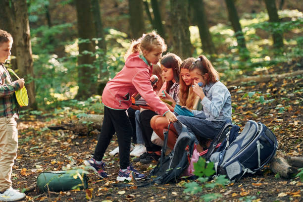 istock Kids in green forest at summer daytime together 1369951041