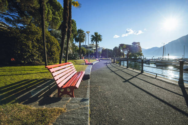 rote bank an der seepromenade des lago maggiore in locarno - seepromenade stock-fotos und bilder