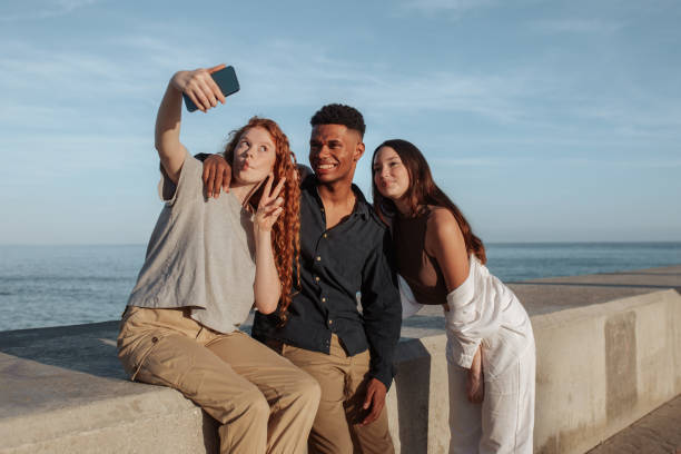 istock Three friends taking a selfie together next to the sea 1369951654