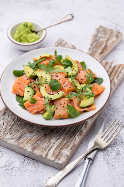 istock Fresh salmon salad with avocado,  for keto and low carb diet. Rusty background, top view, copy space. 1369953047