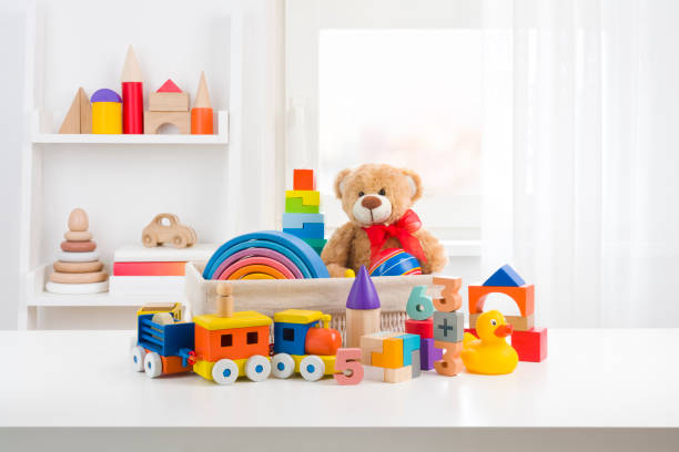 Various cute toys collection on wooden table in children room stock photo