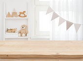 istock Wooden desk on blurred child room or kindergarten interior background 1369955851