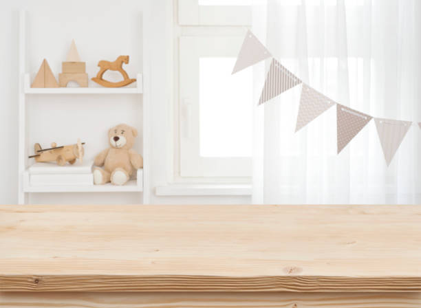 Wooden desk on blurred child room or kindergarten interior background stock photo