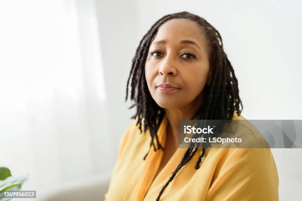 Portrait Of An African Woman Sit On The Sofa Look Worry Stock Photo - Download Image Now