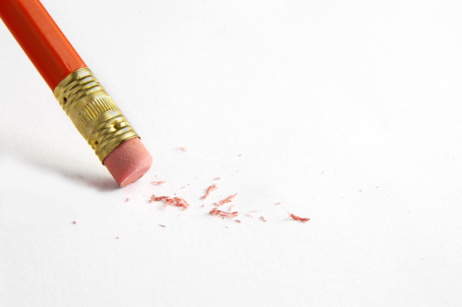 Pink and blue eraser and it’s shavings sitting on a clean white sheet of paper with copy space – Small office supply for correcting errors – Concept image for erasing mistakes and editing