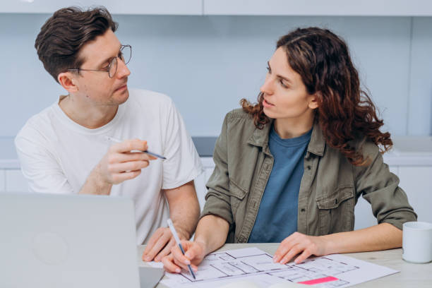 istock Couple talks about drawings of appartment renovation 1369958155