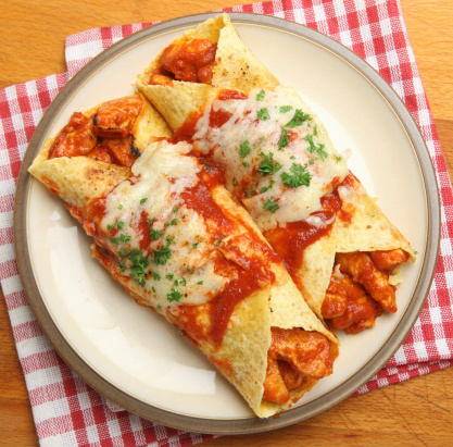 Chicken enchiladas with spicy tomato sauce and melted cheese.