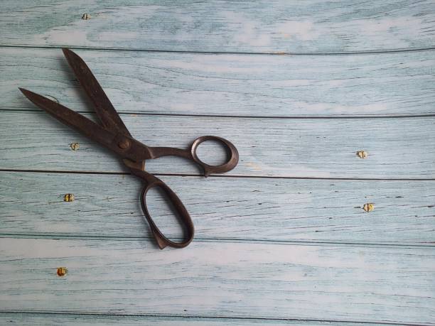 istock Old rusty scissors, isolated, on a wooden table, top view with space for text. 1369961167