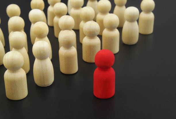 istock Wooden figure stand in formation and leader standing forward. 1369962158