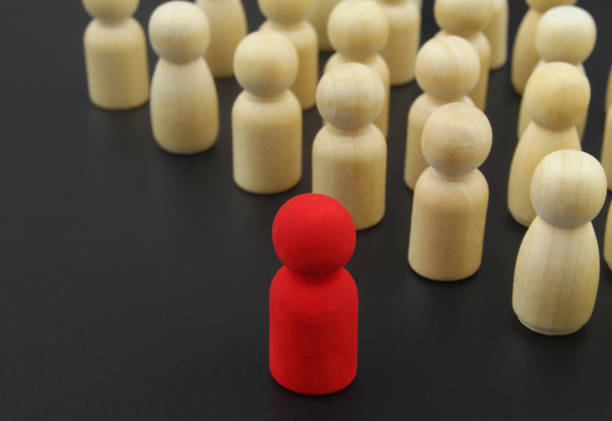istock Wooden figure stand in rows and leader standing forward. 1369962172
