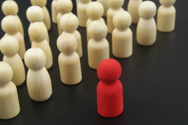 istock Wooden figure stand in formation and leader standing forward 1369962178