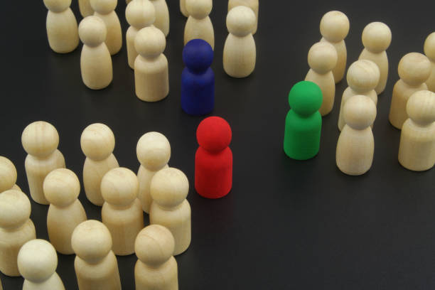 istock Wooden people figures divided into groups with leaders. 1369962458