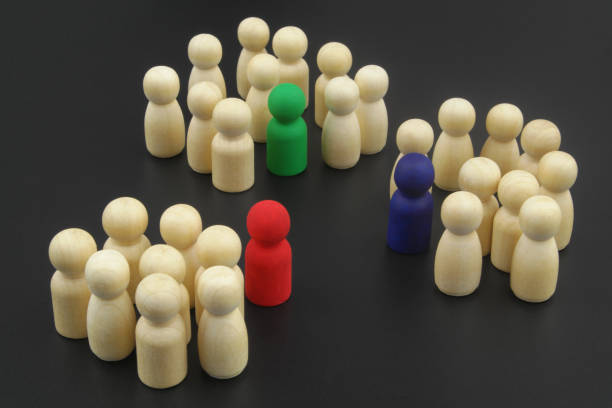 istock Wooden people figures divided into groups with leaders. 1369962601