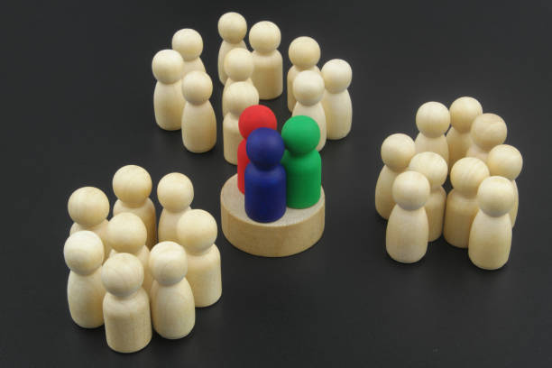 three colored wooden figures as leaders standing near crowd of other figures. - surrounding leadership organization meeting imagens e fotografias de stock