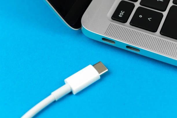 istock Charging laptop with modern USB Type C port. Laptop low battery concept, technology background, office table top view photo 1369964358