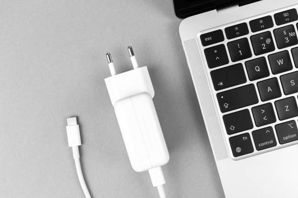 istock Modern USB Type C charger for laptop. Low battery concept, technology background, office table top view photo 1369964365