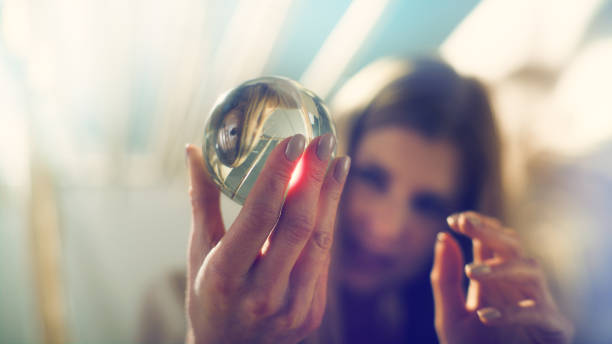 istock Seductive female fortune teller holding glass sphere. Inside tent 1369964713