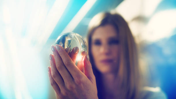 istock Seductive female fortune teller holding glass sphere. Inside tent 1369964716