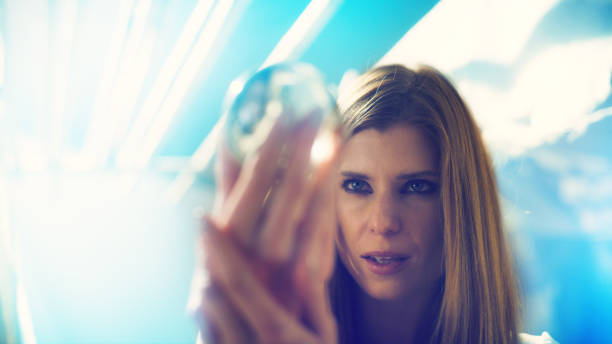 istock Seductive female fortune teller holding glass sphere. Inside tent 1369964732