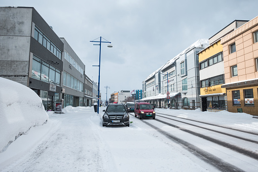 Finnsnes, Norway - Mar 21 2018 : Snow covered on small town with building office and road traffic in overcast day