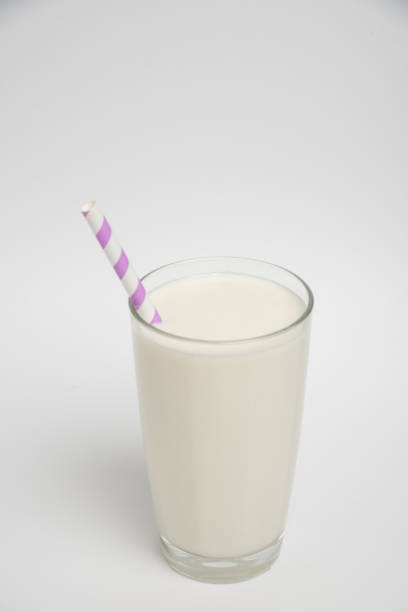 istock Milk glass with colored straw close-up on a white background 1369967462