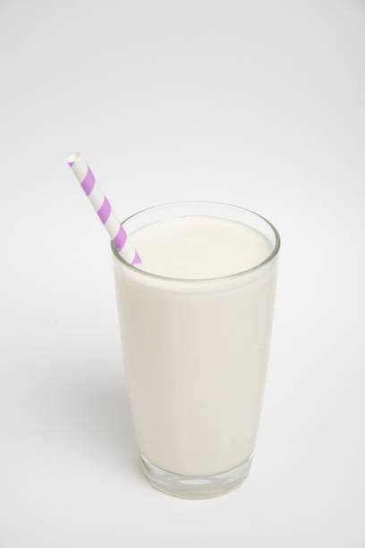 istock Milk glass with colored straw close-up on a white background 1369967463