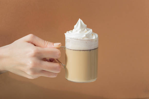 istock hand latte coffee on brown background 1369967853