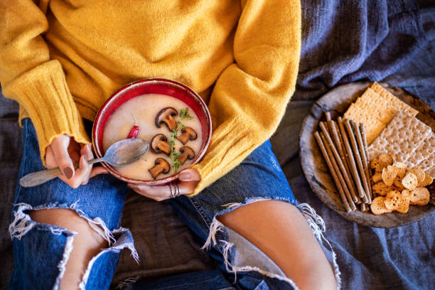 istock A young girl drinks her soup at her bed. 1369967886