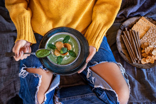 istock A young girl drinks her spinach and broccoli soup at her bed. 1369968016