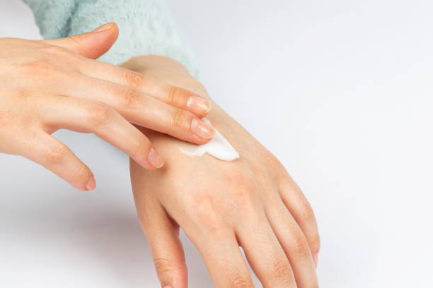 istock woman applying cream on her hand on a white background 1369969117