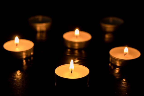 istock Four candles Burning out of six on dark table (black background) Memory day 1369970606