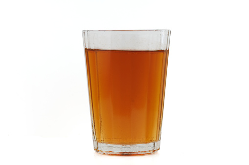 A refreshing pint of cold beer on a wood surface with white background.