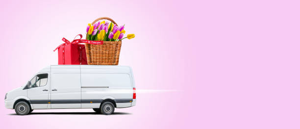 istock Delivery van with tulips and red parcel on a pink background. 1369971228