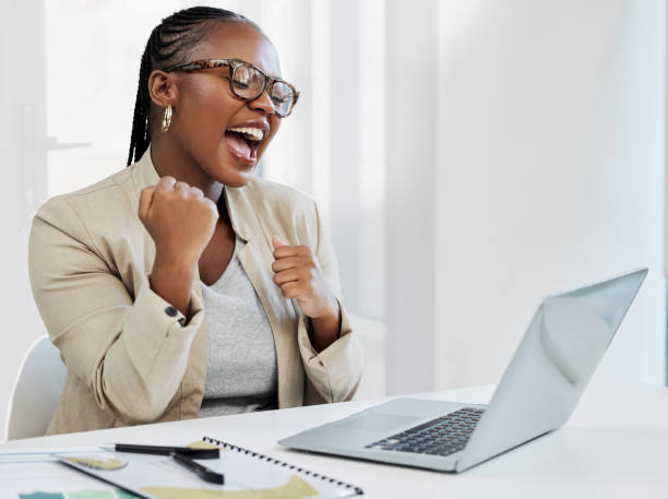 scatto di una giovane imprenditrice che applaude mentre usa un laptop in un ufficio - excitement business person ecstatic passion foto e immagini stock