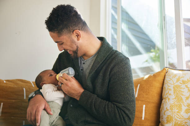 istock Smiling dad feeding his adorable baby boy with a bottle 1369972781
