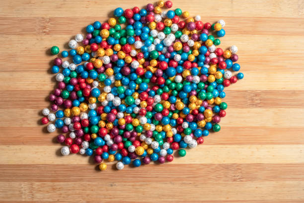 istock Multi-colored small thermocol decorative balls on a wooden table 1369972970