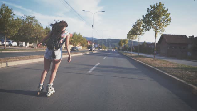 Young woman driving roller skates down the street