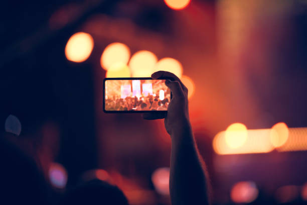 istock Person holding modern smartphone on a concert. 1369974118