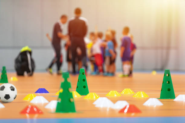 pista de entrenamiento de fútbol sala. niños en grupo con entrenadores en fondo borroso. niños en clase de educación física en la escuela - gimnasia fotografías e imágenes de stock