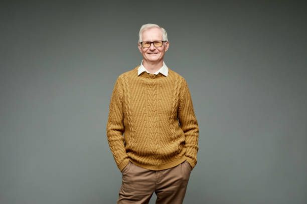istock Happy elderly man in knitted sweater and brown pants 1369974603