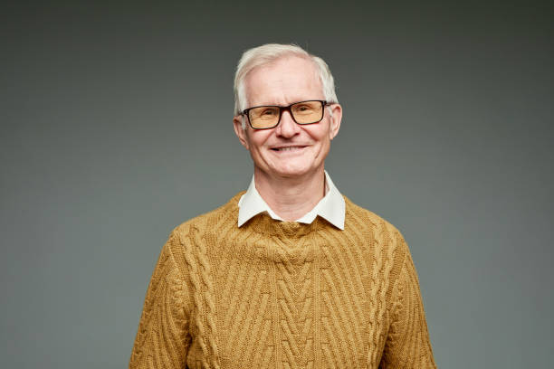 istock Cheerful aged grey haired man wearing brown knitted sweater 1369974607