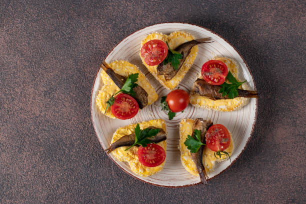 sandwiches with sprats, cheese and cherry tomatoes in the form of hearts on a brown background, idea for valentine's day - cherry valentine stok fotoğraflar ve resimler