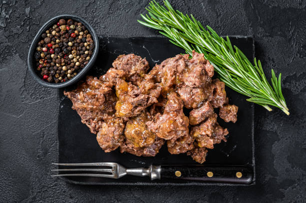 istock Stewed lamb and beef meat on a marble board. Black background. Top view 1369975961