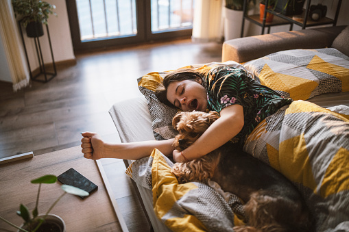 Young woman and her dog waking up in the morning.